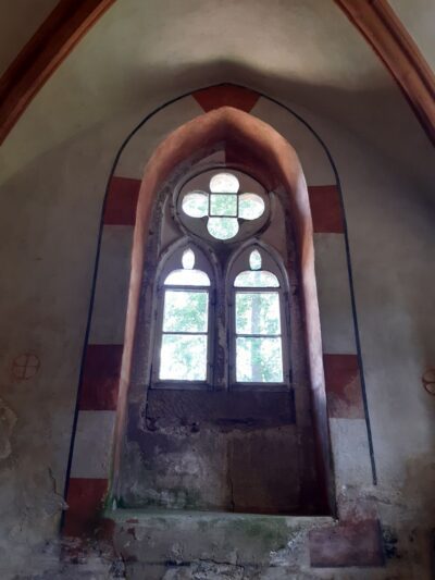 Fenster der Kapelle mit 2 Radkreuzen links und rechts